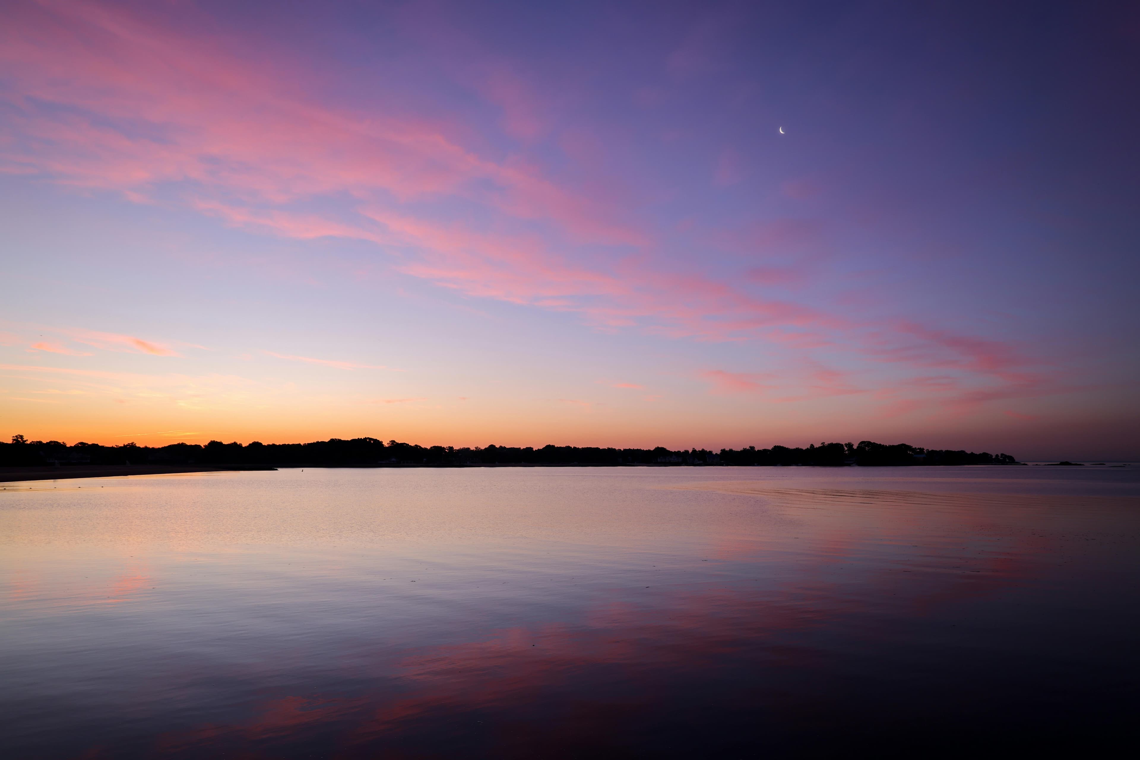 Aerial view of Xi'an city skyline at dusk with the historic Bell Tower in the center, surrounded by a mix of traditional and modern architecture, with the ancient city wall visible in the foreground